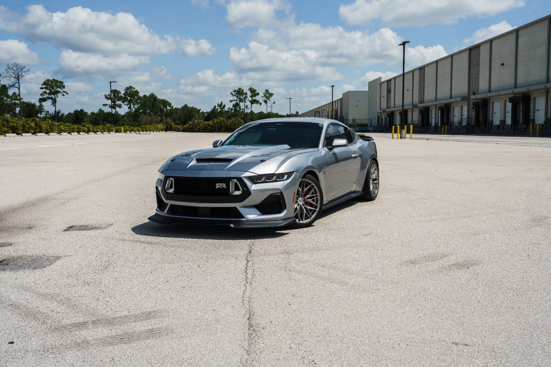 Wide shot of silver Mustang RTR alone on industrial lot