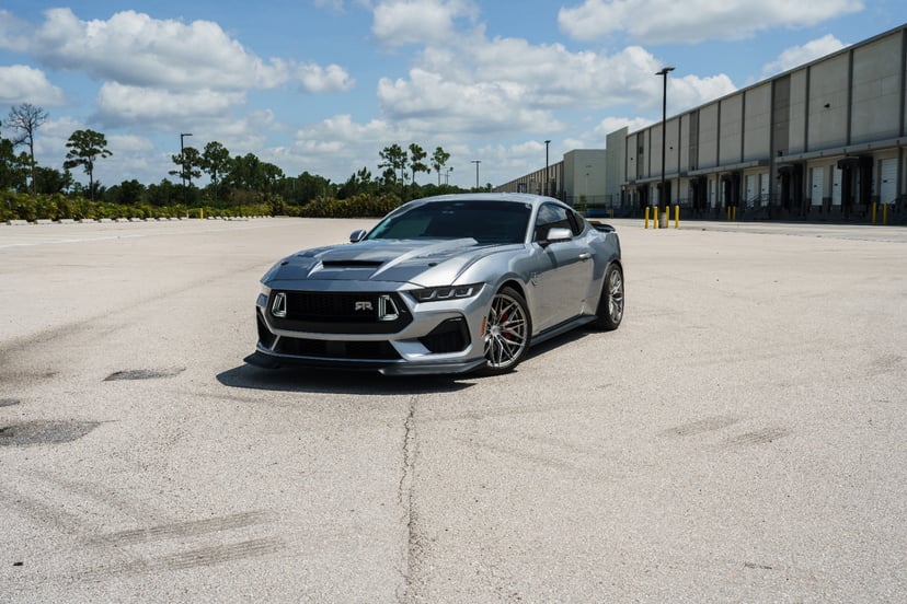 Wide shot of silver Mustang RTR alone on an industrial lot
