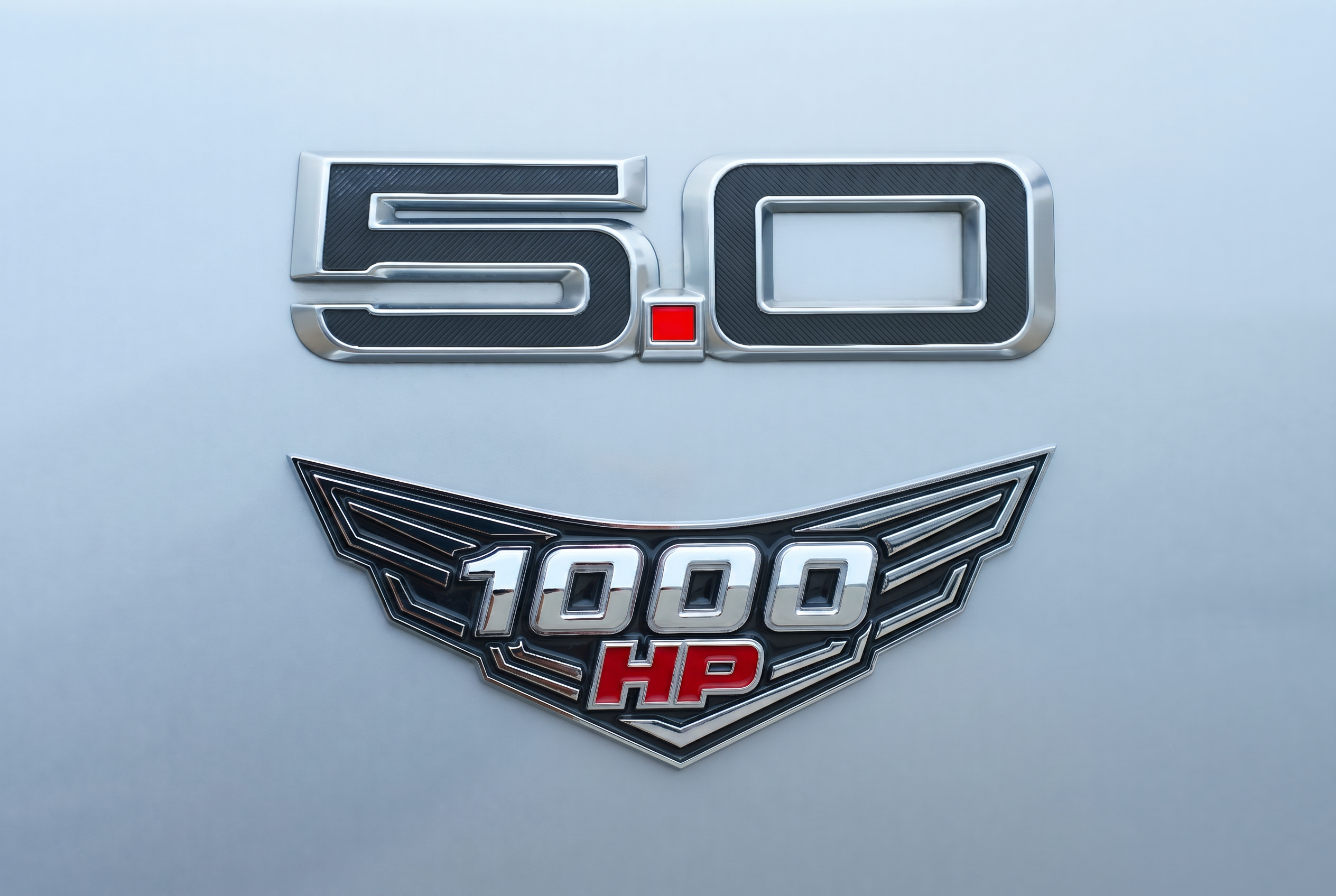 Close-up of factory 5.0 badge with Kilo Performance HP1000 winged emblem installed